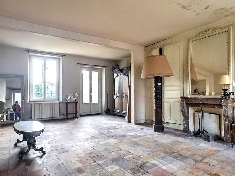 Grand salon avant travaux, tommettes usées et plafond taché