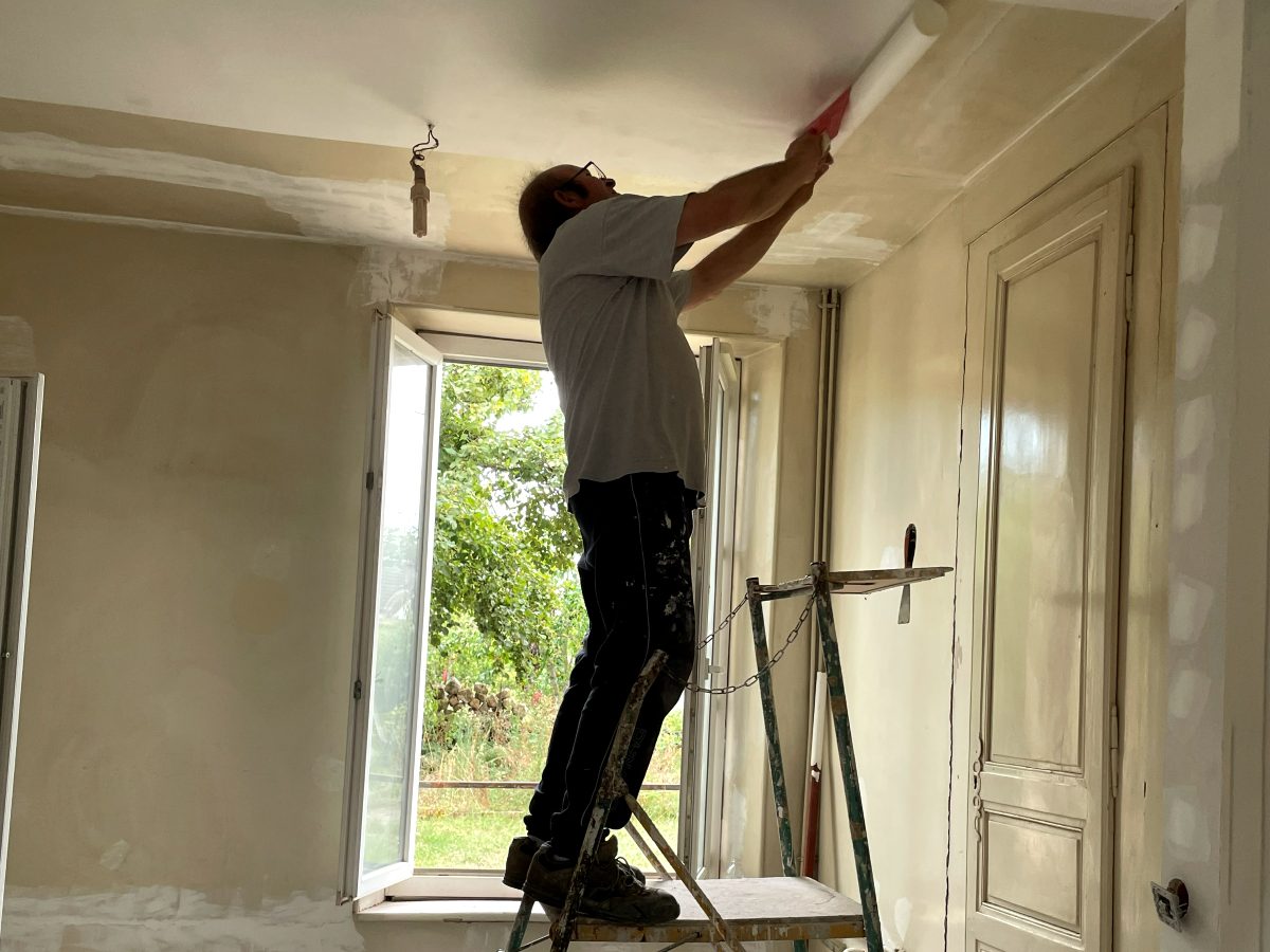 Pièce vidée, reprise du plafond au rouleau depuis un échafaudage roulant