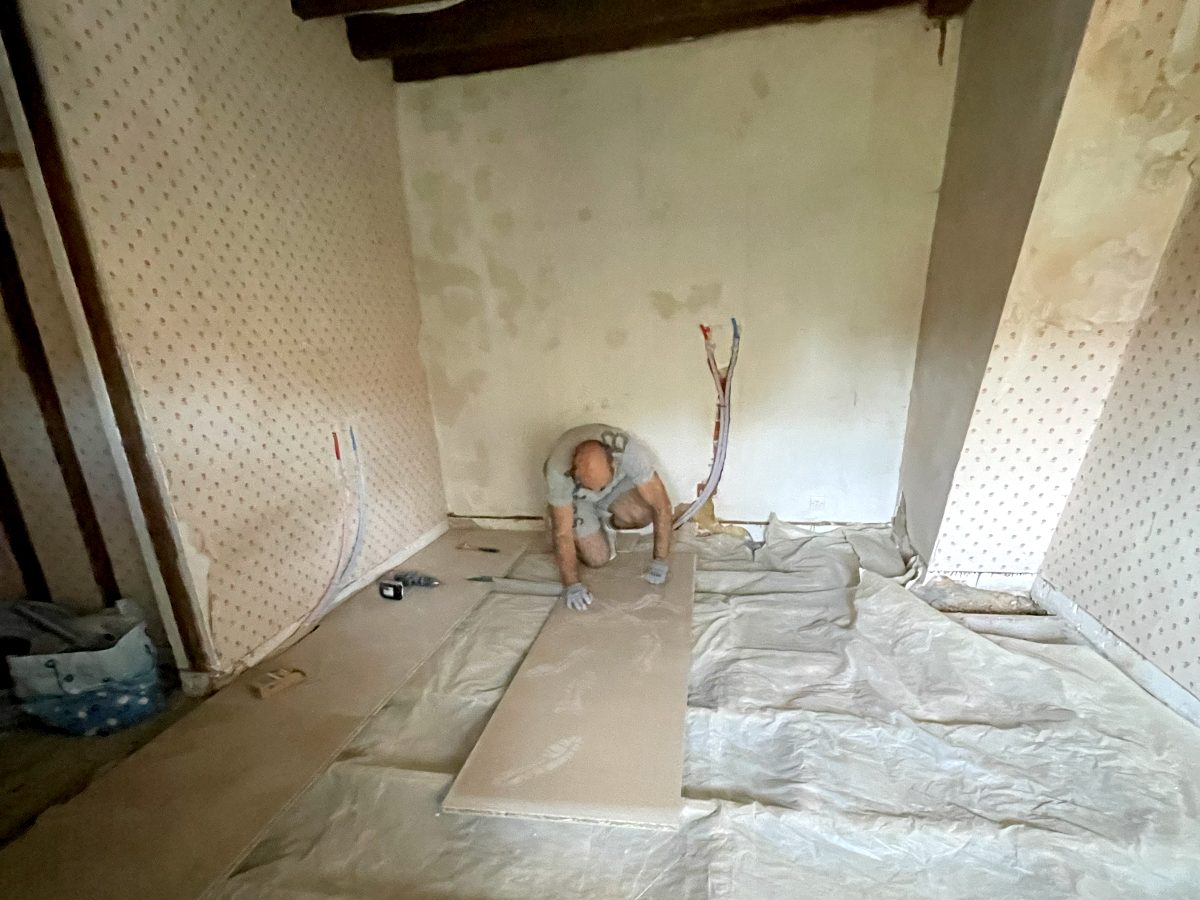 Pièce en chantier, sol protégé, plaques de plâtre et gaines électriques